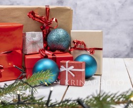 Christmas holiday composition with gift boxes on white wooden background. Christmas presents with red, brown and gray paper with red ribbon, Christmas decorations around.