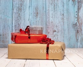 Composition with lots of gifts and copy space for your best wishes.
Red, brown and silver gift boxes on a white wooden table for a Christmas full of love. Christmas concept