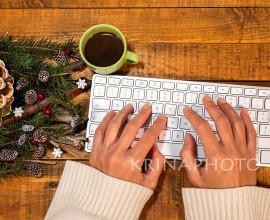 A Xmas touch on a smart working desk. Even a computer desk can get a merry makeover with some joyful details: a gold and white painted pine cone, green fir branches, red berries and wooden snowflakes.