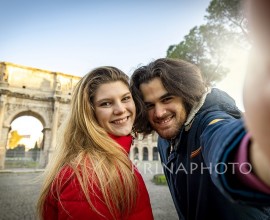 Say cheese! Young charming couple making a selfie in the historical center of Rome, near the Arch of Titus.