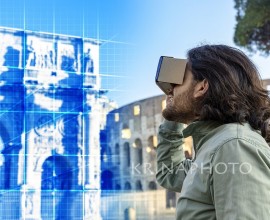 Young man in Piazza del Colosseo (Rome) looks at a virtual reconstruction with a cardboard viewer. The landscape around him changes, taking him on a journey through time and space.