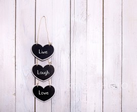 Three heart-shaped chalckboards hanging on a white wooden background. Write a sweet memo for your love.chalkboard hanging on a white wooden background.
